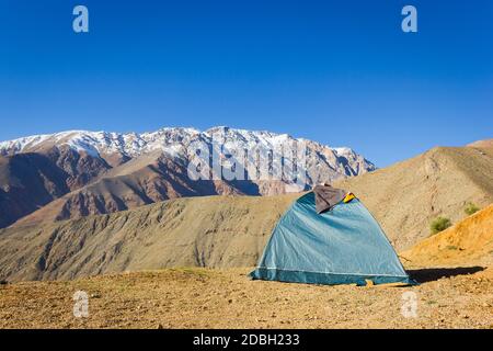 Iglu grünes Camping-Zelt auf trockenem Boden mit herrlichem Blick auf die Anden schneebedeckten Bergkette auf dem Hintergrund unter blauem Himmel im Elqui-Tal, Chile Stockfoto