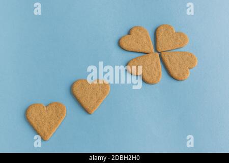 Frühstück. Nahaufnahme von herzförmigen Plätzchen wie Blütenblätter. Blauer Hintergrund. Speicherplatz kopieren Stockfoto