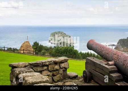 Alte Kanone zeigt auf Insel an der baskischen Küste, Nordspanien. Konzept der antiken Kriegswaffen Stockfoto