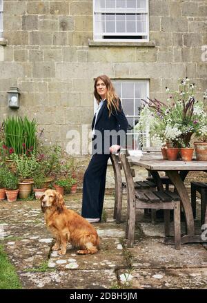 Innenarchitektin Flora Soames und ihr Hund Humbug, fotografiert in ihrem Wiltshire Zuhause. Flora trägt einen Cord-Anzug aus dem Deck London. Stockfoto