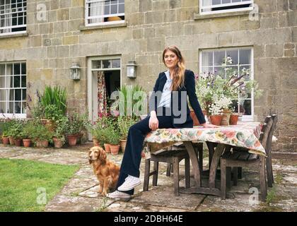 Innenarchitektin Flora Soames und ihr Hund Humbug, fotografiert in ihrem Wiltshire Zuhause. Flora trägt einen Cord-Anzug aus dem Deck London. Stockfoto