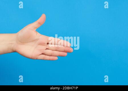 Ausgestreckte Hand des Menschen, offene Hand, Körperteil auf blauem Hintergrund, Nahaufnahme Stockfoto