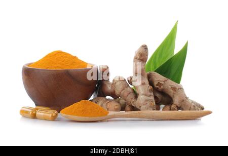 Kurkuma, Kurkuma Pulver in Holzbecher mit Holzlöffel und Kurkuma Kapseln auf weißem Hintergrund. Stockfoto