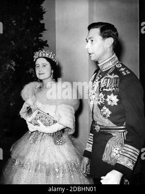 Königin Elizabeth und König Georg VI. Bei ihrer Ankunft im Opernhaus des Konventgartens zu einer Galavorstellung anlässlich des Staatsbesuchs des französischen Präsidenten Albert Lebrun. Die Königin trägt ein Kleid mit einem Crinoline. Stockfoto