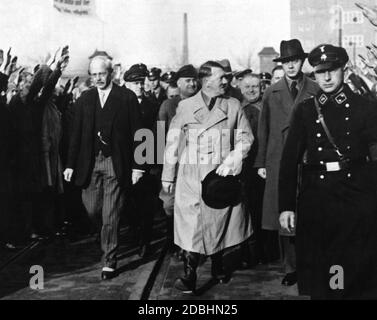 Bei einer Betriebsversammlung der Siemens Werke in Berlin werden Carl Friedrich von Siemens und Adolf Hitler von weiteren Siemens-Mitarbeitern und SS-Mitgliedern begleitet. Stockfoto