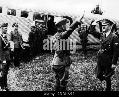 Adolf Hitler wird in Polen von Walter von Reichenau an einer Front-Landepiste begrüßt. Im Hintergrund Hitlers Wehrmachtsadjutant Engel und der Pilot des Führers, Hans Baur, zusammen mit Soldaten der Luftwaffe. Stockfoto