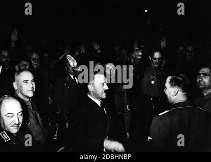 "Das Foto zeigt Adolf Hitler und die Gefolgschaft (links Wilhelm Frick und rechts Rudolf Hess), als sie ankommen und von seinen "Alten Kämpfern" im Bürgerbraeukeller im Münchner Stadtteil Haidhausen begrüßt werden." Stockfoto