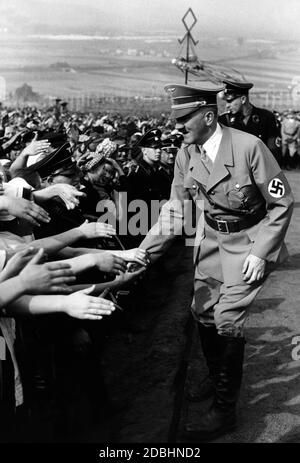Adolf Hitler schüttelt die Hände auf dem Weg zum Podest auf dem Bueckeberg. Stockfoto