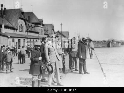 Kronprinz Wilhelm von Preußen (Bildmitte, karierter Anzug) blickt auf der Bremerhavener Hafenmauer zum Meer. Er wartet auf die Ankunft seiner Frau Cecilie von Mecklenburg. Im Hintergrund das Gebäude des Norddeutschen Lloyd. Das Foto wurde im Jahr 1925 aufgenommen. Stockfoto