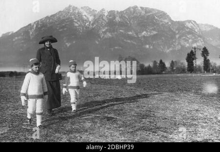 Kronprinzessin Cecilie von Preußen (geboren in Mecklenburg) spaziert 1912 mit ihren ältesten Söhnen, Prinz Wilhelm (links) und Ludwig Ferdinand (rechts) von Preußen, bei Partenkirchen. Im Hintergrund der Kramerspitz. Stockfoto