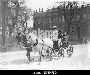 Kronprinzessin Cecilie von Mecklenburg sitzt mit einem Mädchen in einer Kutsche und fährt durch Potsdam. Hinter ihnen sitzt ein Kutscher. Im Hintergrund links die Nikolaikirche, rechts ein Teil des Potsdamer Stadtpalastes. Das Foto wurde 1907 vom Hoffotografen Ernst Eichgruen aufgenommen. Stockfoto