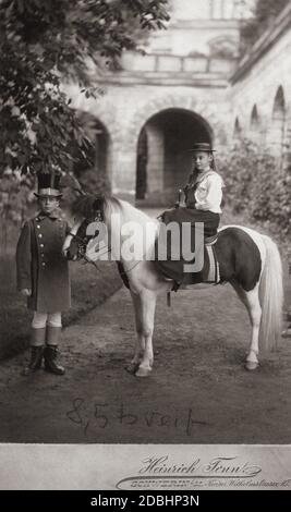 Cecilie von Mecklenburg sitzt in einem Seitensattel auf einem Pony, das von einem Jungen mit Zylinderhut gehalten wird. Foto von Heinrich Tonn, einem Schweriner Fotografen. Stockfoto