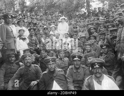 Kronprinzessin Cecilie von Preußen (geboren in Mecklenburg, Mitte) besucht 1915 deutsche Soldaten mit ihren Söhnen Wilhelm, Hubertus und Ludwig Ferdinand von Preußen (Mitte, links nach rechts). Die Kinder tragen Matrosenanzüge und Kappen mit der Aufschrift ''S.M.S. Kronprinz''. Die Soldaten sind in Zoppot in Westpreußen stationiert (heute Sopot in Polen), darunter auch einige kriegsbehinderte Soldaten." Stockfoto