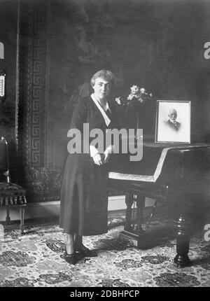 Das Foto zeigt Hermine Reuss Elder Line, die zweite Ehefrau von Kaiser Wilhelm II., im Alter von 44 Jahren. Sie steht vor einem Klavier, auf dem sich ein Porträt von Wilhelm II. Befindet Stockfoto