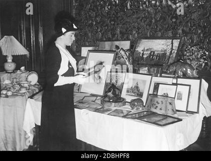 Hermine Reuss Elder Line, die zweite Gemahlin Kaiser Wilhelms II., war im Dezember 1932 auf dem Weihnachtsmarkt des Herminenhilfswerks einkaufen. Hier steht sie an einem Tisch mit Figuren und Bildern. Der Markt fand in den Räumen des Garde-Kavallerie-Vereins in der Friedrich-Ebertstraße 15 (heute Ebertstraße) in Berlin statt. Stockfoto