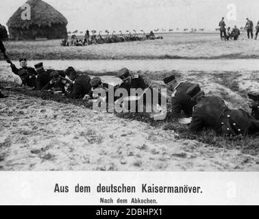 Soldaten machen nach dem Mittagessen eine Pause und kochen die Töpfe. Stockfoto