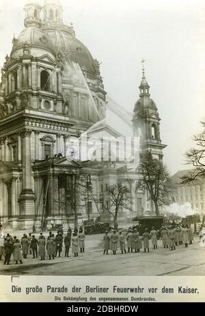 Im Winter 1914 übte die Feuerwehr einen Noteinsatz im Berliner Dom aus. Mehrere Fahrzeuge und Teams mit Drehleitern traten an und richteten ihre Feuerwehrschläuche auf den Dom. Vor dem Dom folgte Kaiser Wilhelm II. Der Übung mit einem Gefolge von Offizieren und Militärpersonal. Stockfoto