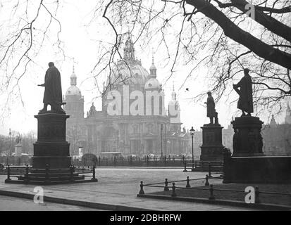 Das Foto zeigt drei Statuen auf dem Schinkelplatz und dem Berliner Dom im Jahr 1937. Die Statuen ehren Albrecht Daniel Thaer (links), Christian Peter Wilhelm Beuth (rechts) und Karl Friedrich Schinkel (ganz rechts). Stockfoto