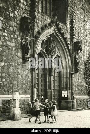 Das Foto von 1933 zeigt Kinder, die vor dem Haupteingang der Marienkirche in Berlin-Mitte spielen. Stockfoto