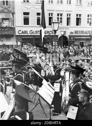 "Die Academia Musica der Opera Nazionale Balilla (Jugendorganisation der italienischen Faschisten) spielt 1937 in der Kranzler-Ecke (Straße unter den Linden, Ecke Friedrichstraße) in Berlin ein Konzert. Ein großes Publikum hat sich auf der Straße versammelt. Im Hintergrund ist die Terrasse eines Restaurants auf der linken Seite, in der Mitte des Bildes der Zigarrenladen ''Carl Gust. Gerold''' im Gerold Haus und rechts der Hutladen ''Neubauer'''. Stockfoto