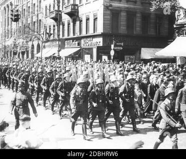 'Das Foto vom April 1935 zeigt den Einsatz einer Wacheinheit der neuen deutschen Luftwaffe an der Straßenecke unter den Linden, Friedrichstraße in Berlin. Begleitet von den Zuschauern laufen die Soldaten der Luftwaffe zum Wachwechsel. Erst im März 1935 wurde die allgemeine Wehrpflicht im nationalsozialistischen Deutschland wieder eingeführt. Das Zigarrengeschäft ''Krueger und Oberbeck'' befindet sich an der Straßenecke.' Stockfoto