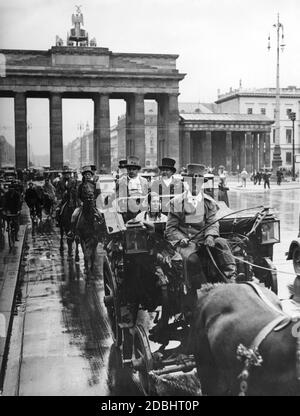 "Am Mittwoch, den 15. Juli 1936, fuhr Goethes Bus durch viele Straßen in Berlin. Es war für die "Deutschen"-Show in die Stadt gebracht worden. Das Bild zeigt die historische Kutsche und ihre Passagiere in Biedermeier-Tracht auf der Ost-West-Achse (heute: Straße des 17. Juni) am Brandenburger Tor.' Stockfoto