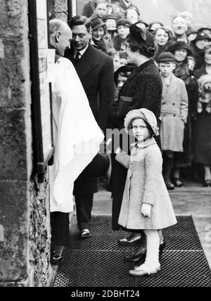 Prinzessin Margaret mit ihrer Mutter Elizabeth Bowes-Lyon und ihrem Vater George VI. Vor der St. Mary's Church in Eastbourne. Reverend F.P. Hughes heißt sie willkommen. Stockfoto