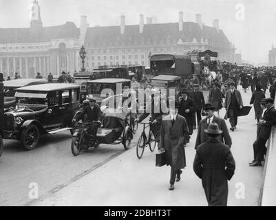 Passanten überqueren die Westminster Bridge zu Fuß auf ihrem Weg zur Arbeit während des lokalen Verkehrsstreiks. Im Hintergrund befindet sich die Bezirkshalle. (Undatierte Aufnahme) Stockfoto