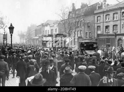 Vor der Londoner U-Bahnstation Elephant & Castle wird ein ausgebrannter Tilling-Stevens-Bus geschleppt. Streikende Arbeiter hatten sie in Brand gesetzt. Stockfoto