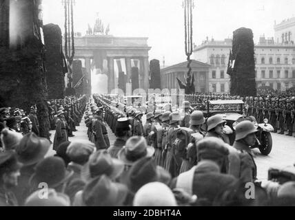 Eine Ehrenwache der Reichswehr steht auf dem Pariser Platz vor dem Brandenburger Tor beim Besuch des afghanischen Königs Amanullah Khan im Februar 1928. Im ersten Auto fahren Admiral Hans Zenker (links, mit doppelspitziger Mütze) und General Wilhelm Heye (Oberbefehlshaber der Armee) mit zwei afghanischen Offizieren. Stockfoto