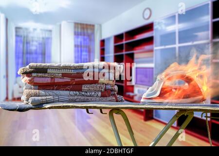 Feuer, das durch defekte elektrische Haushaltsgeräte verursacht wird. Jemand vergaß, das Bügeleisen abzustellen, was zu Flammen führte. Stockfoto