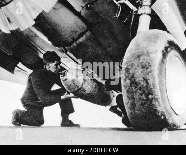 'Ein Soldat montiert eine Bombe auf einem US Curtiss P-40 ''Kittihawk'', der Missionen in Afrika unter englischem Emblem fliegt. (Undatierte Aufnahme)' Stockfoto