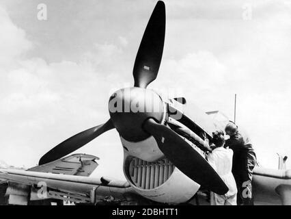 Auf dem Gelände der Junkers Werke diskutiert der Testpilot einer Junkers Ju 87 Details eines Testfluges. Am Zwölfzylindermotor des Flugzeugs, einem JUMO 211, müssen noch Anpassungen vorgenommen werden. Stockfoto