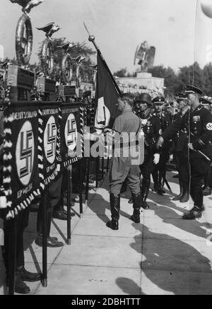 Adolf Hitler bei der Weihe der Fahne in der Luitpoldarena auf dem Nazi-Parteitag 1934, wo Hitler neue Maßstäbe ansetzt, darunter die Fahne von Heilbronn mit der Fahne des Bierhallputsches von 1923, der sogenannten Blutflagge. Stockfoto