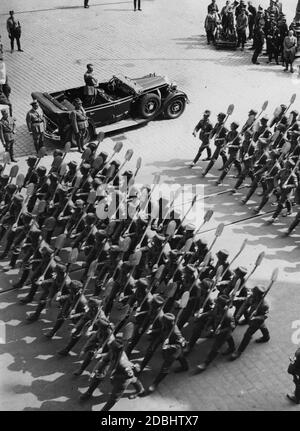 Adolf Hitler, der in einem Mercedes steht, grüßt den Reichsarbeitsdienst auf dem sogenannten Adolf-Hitler-Platz in Nürnberg. Auf der rechten Seite ist ein Kamerateam. Links neben dem Auto, Rudolf Hess. Stockfoto