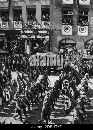 Blick auf einige Formationen der SA und SS, die auf dem NSDAP-Kongress in Nürnberg am festlich geschmückten sogenannten Adolf-Hitler-Platz vorbeimarschieren. Hier vor der ehemaligen Residenz von Willibald Pirckheimer. Stockfoto