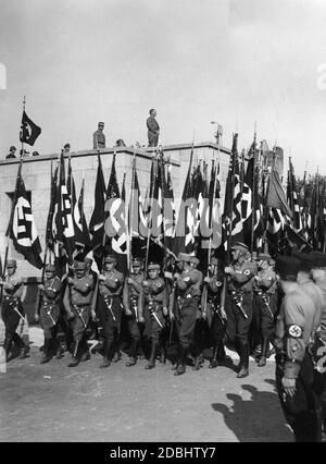 Adolf Hitler und hinter ihm Viktor Lutze beobachten vom Podium aus die Parade der SA- und SS-Formationen in der Luitpoldarena während des NSDAP-Kongresses in Nürnberg. Stockfoto