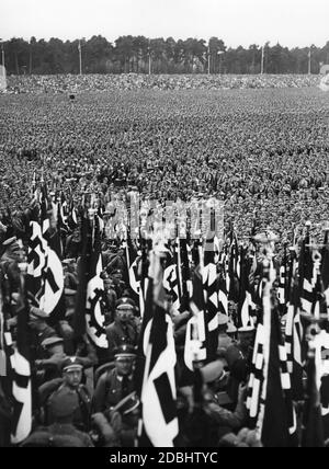 Übersicht über die Parade auf dem Marschplatz der Luitpoldarena während des NSDAP-Kongresses in Nürnberg. Im Vordergrund sind Hakenkreuzfahnen und Flaggen der Deutschen Arbeitsfront zu sehen. Stockfoto