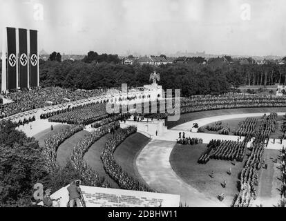 Die Formationen der SA, SS und NSKK Reihen sich in der Luitpoldarena auf dem Gelände der Reichsparteitagsversammlung ein. Im Vordergrund ein Fotograf mit seiner Kamera auf einem Stativ, links das Rostrum. Stockfoto