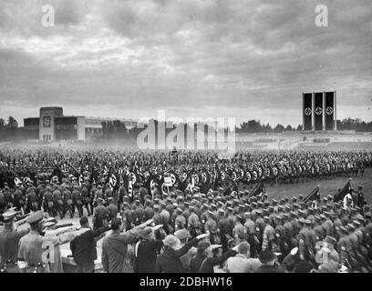 Die Parade von SA, SS und NSKK in der Luitpoldarena auf dem Gelände der NSDAP beginnt früh morgens im Nebel. Im Vordergrund die Ostmark-Gruppe, rechts das Rostrum. Im Hintergrund befindet sich die Luitpoldhalle, die mit einem Hakenkreuz dekoriert ist. Stockfoto