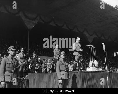 Adolf Hitler hält eine Rede vor den rund 45,000 Mitgliedern der HJ im Stadion der Hitlerjugend. Hinter ihm steht Reichsjugendführer Baldur von Schirach, etwas links Rudolf Hess, hinter ihm Bernhard Rust und rechts Julius Schaub. Hinter ihm Schirach Rudolf Schmundt. Stockfoto