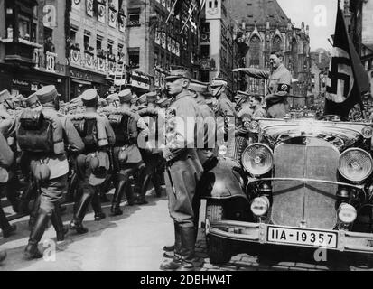Nach der Kundgebung in der Luitpoldarena begrüßt Adolf Hitler die SA-Formationen in einem Mercedes auf dem Nürnberger Hauptmarkt. Neben Hitler ist Rudolf Hess. Im Hintergrund die St. Sebaldus Kirche. Stockfoto