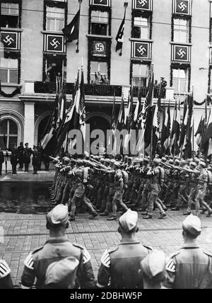 "Adolf Hitler, auf dem Balkon des Deutschen Hofes, grüßt die rund 1,600 Teilnehmer des Adolf-Hitler-Marsches der Hitlerjugend. Neben Hitler steht der Reichsjugendführer Baldur von Schirach. Im linken Fenster ist Martin Bormann, rechts Heinrich Hoffmann.' Stockfoto