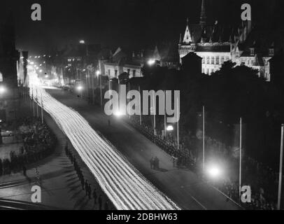 Blick auf den Fackelzug der politischen Organisationen der NSDAP durch die Nürnberger Straßen während des NSDAP-Kongresses, hier an der Kreisstraße beim Germanischen Nationalmuseum (rechts) und links das Opernhaus. Stockfoto