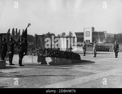 An der Gedenkstätte vor der Halle von Honou in der Luitpoldarena am Tag der SA, SS und NSKK. Von links: Viktor Lutze (Stabschef der SA), Adolf Hitler und Heinrich Himmler (Reichsführer-SS) gedenken der Toten des Bierhaussaales Putsch. Auf der linken Seite sind Männer der SS mit der Blutflagge. Im Hintergrund die Luitpoldhalle. Stockfoto