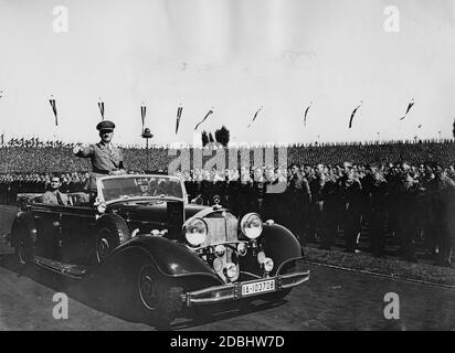 Blick auf den Abgang Adolf Hitlers aus dem Stadion der Hitlerjugend, wo die Parade der Hitlerjugend stattfand. Rudolf Hess sitzt hinter ihm im Mercedes 770 K. Stockfoto