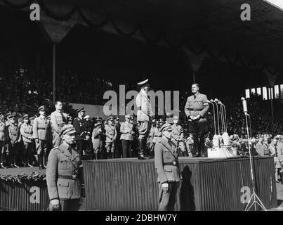 Bei der Parade der HJ im Stadtstadion bittet Baldur von Schirach Adolf Hitler, zu den Massen zu sprechen. Im Hintergrund von links Reichsminister Bernhard Rust und Rudolf Hess, sowie die Adjutanten Julius Schaub und Wilhelm Brückner. Stockfoto