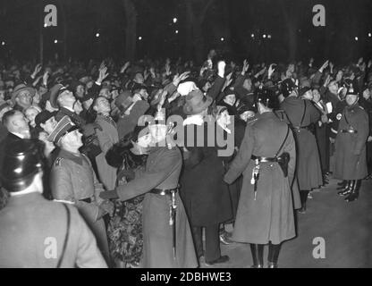 Menschen zu Neujahr vor der Reichskanzlei in Berlin. Das Bild zeigt Polizisten, einen SA-Mann und eine Menschenmenge, die den Nazi-Gruß während der Wartezeit auf Hitler. Stockfoto