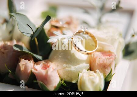 Eheringe in kleiner Blumenschachtel. Wunderschöner Hochzeitstor Stockfoto