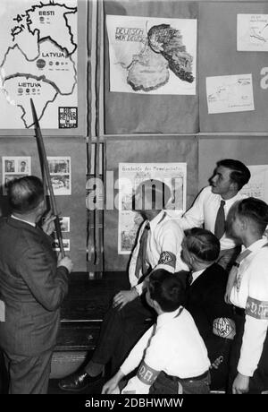 "Eine Lehrerin zeigt einer Gruppe von Schülern der VDA-Jugend eine Karte der Minderheiten in den baltischen Staaten, in der Ausstellung der Schüler des Berliner Koellnischen Gymnasiums mit dem Titel 'Deutsche Not im Memelland''. In der oberen Mitte befindet sich eine Karte von Ostpreußen mit der Aufschrift 'Deutsch hoere, wer deutsch ist'. Auf der rechten Seite ein Blatt über angebliche zwei gewalttätige Einbrüche aus Frankreich und Litauen. In der Mitte unten eine Darstellung der ''Geschichte der Memel-Gegend''.' Stockfoto